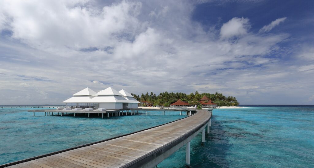 A row of overwater villas above a turquoise lagoon in the Maldives