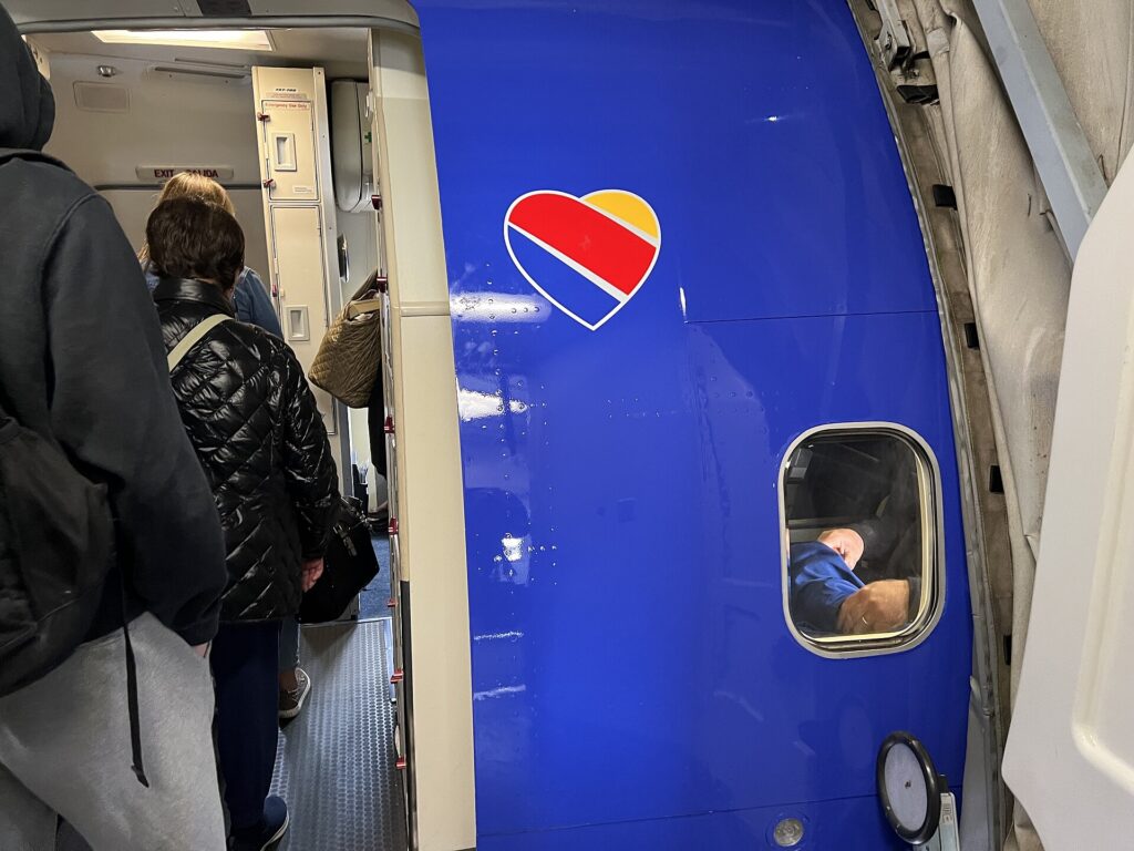 Passengers boarding a Boeing 737 at an airport gate