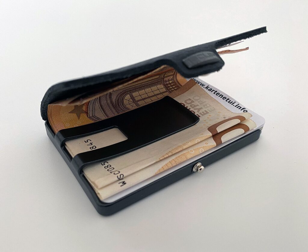A slim minimalist wallet holding cards and euro banknotes