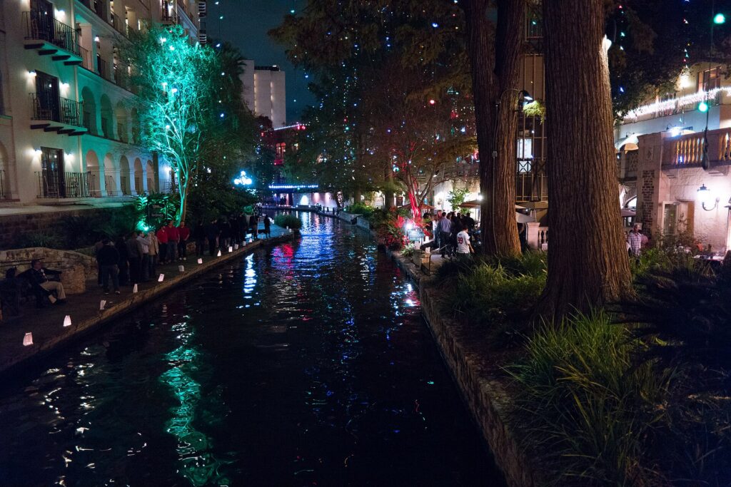 Christmas lights strung through the trees along the San Antonio River Walk at night