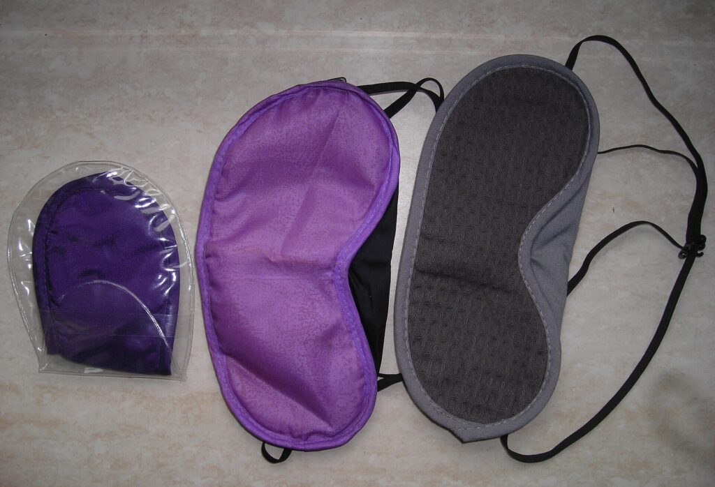 Several sleeping masks from airline amenity kits laid out side by side