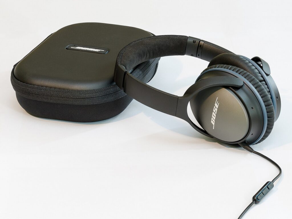 Over-ear noise-cancelling headphones beside their protective carrying case