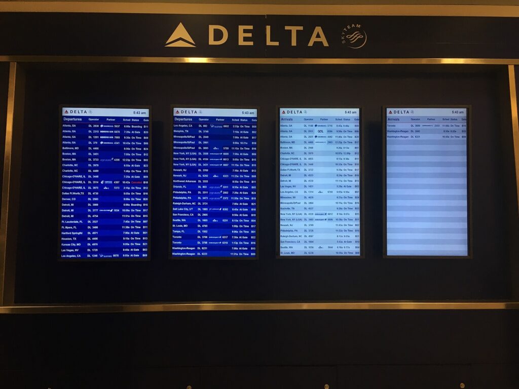 An airport departures board listing flights, times and gates