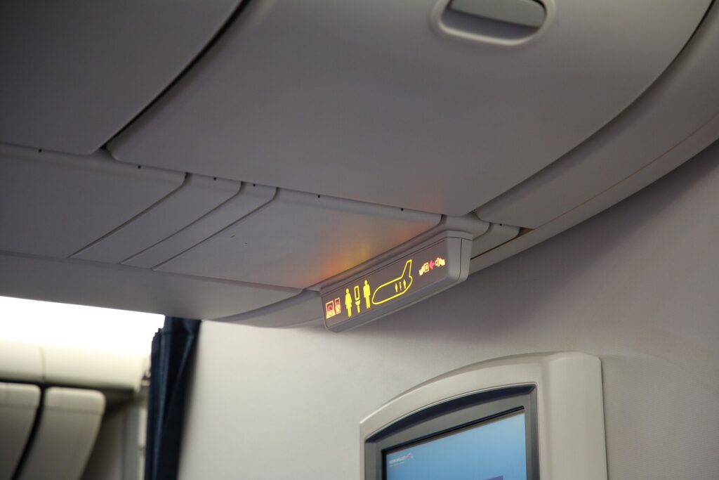 Overhead luggage bins in the cabin of a widebody airliner