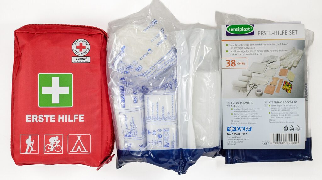A compact first aid kit for leisure and travel laid out with its contents