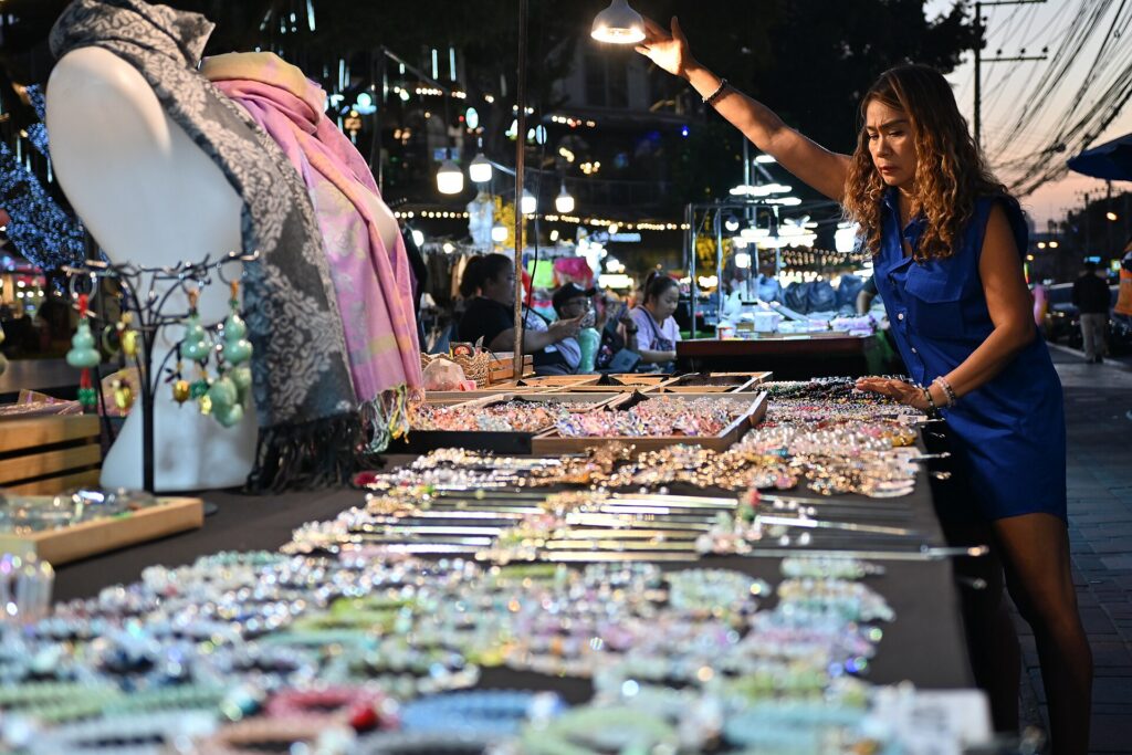 A night market stall with trays of sparkling jewelry and accessories