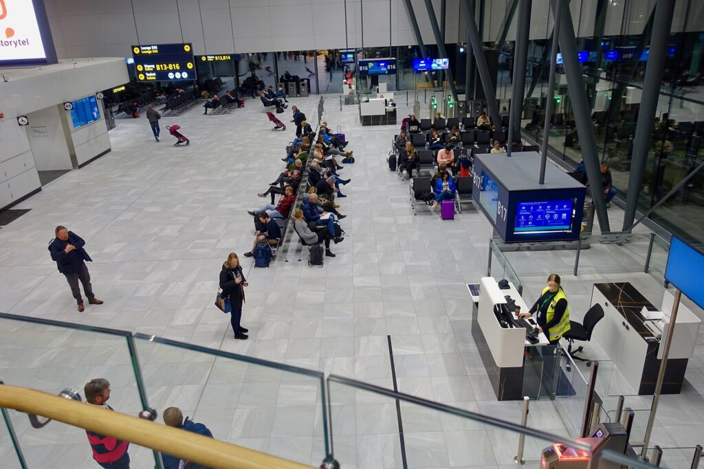 Passengers seated at a departure gate waiting to board a flight