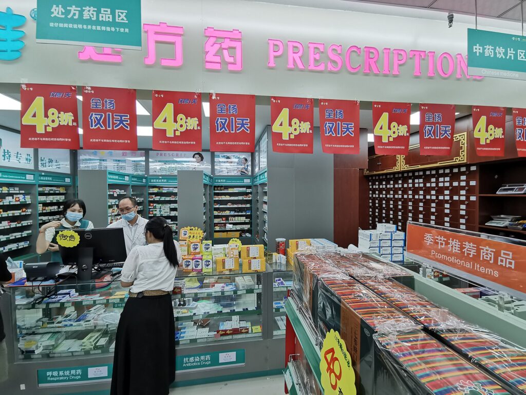 The front of a neighborhood pharmacy in a city