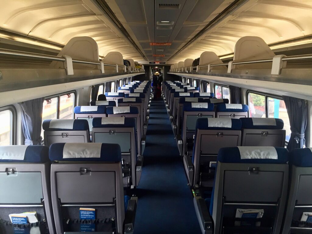The interior of an Amtrak passenger car with rows of seats