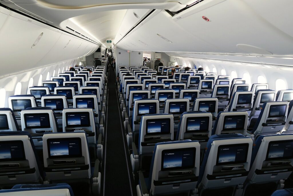 Rows of economy seats with seatback screens in a Boeing 787 cabin