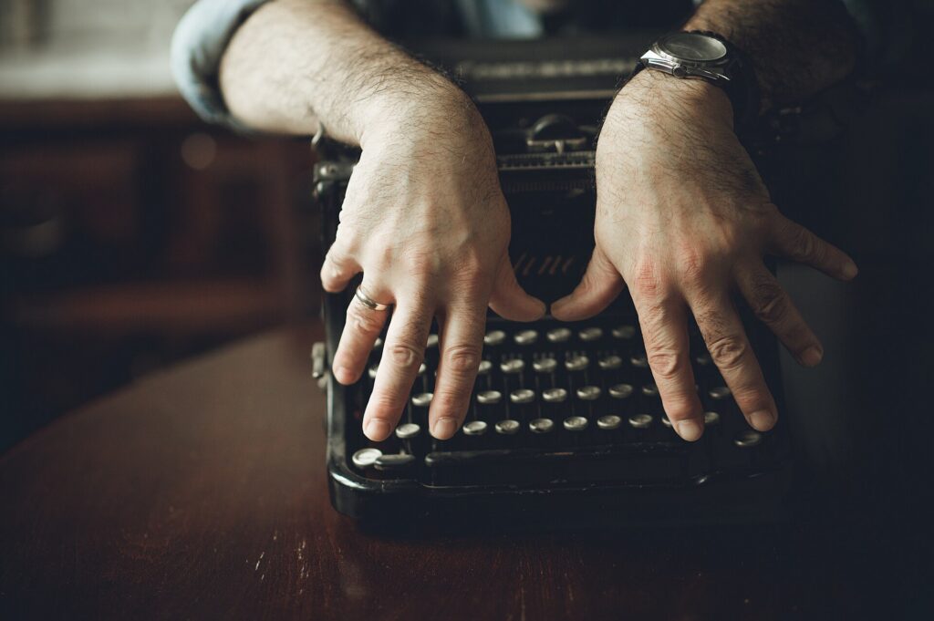 Close-up of hands typing on an old manual typewriter