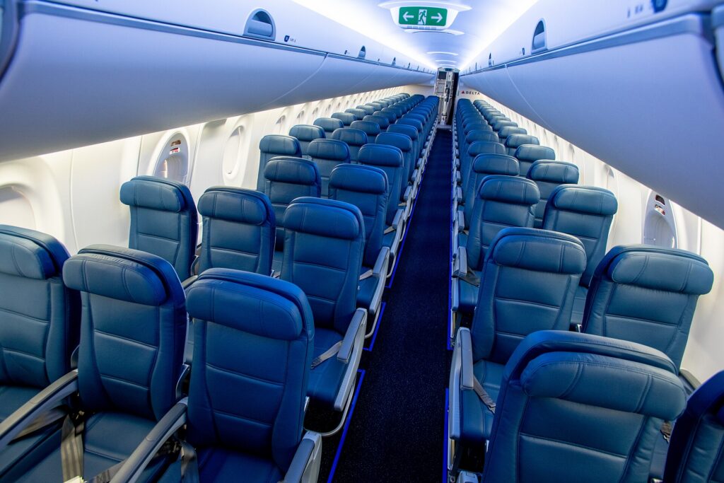 Rows of economy seats in the main cabin of a narrowbody airliner