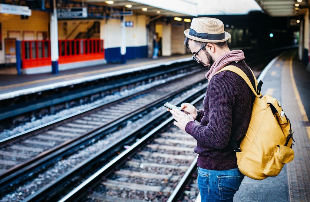 A traveler with a large backpack waiting on a railway platform