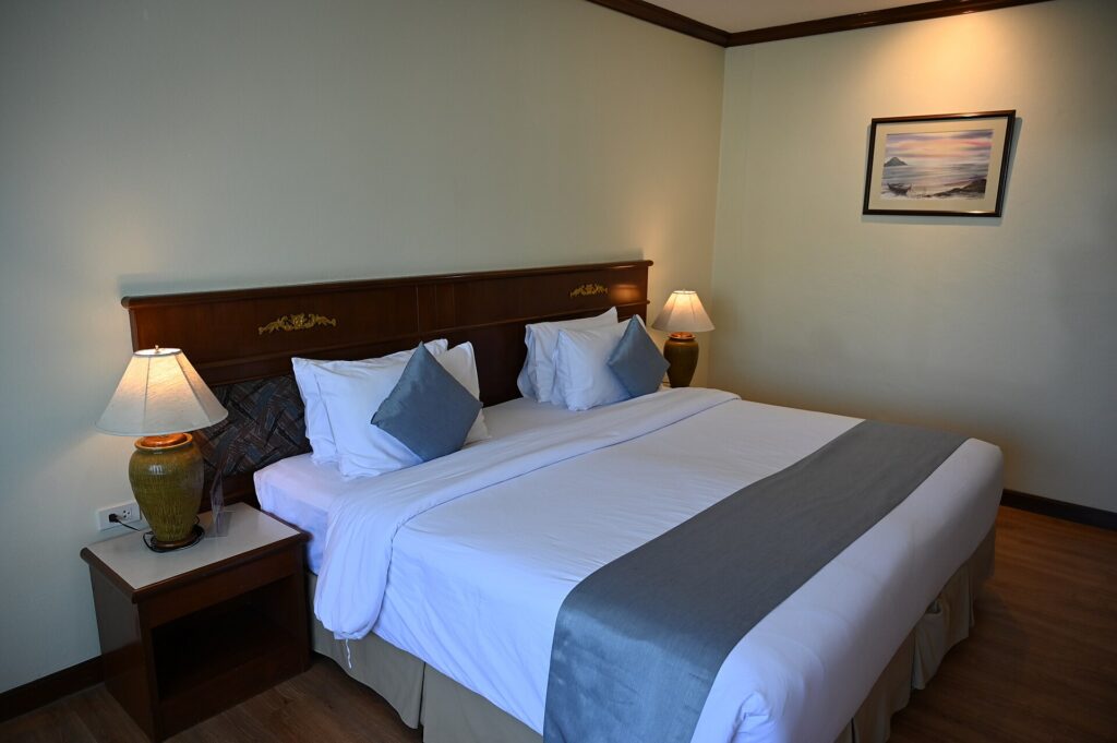 A neatly made hotel room with a king bed and bedside lamps