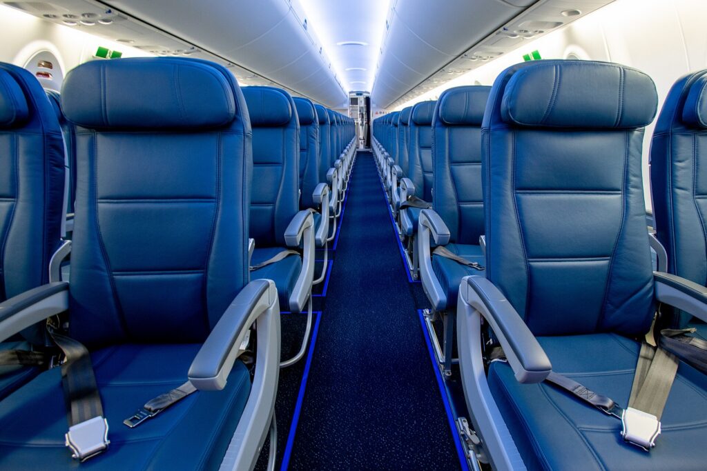 The main cabin of a Delta Air Lines Airbus A220 with overhead bins