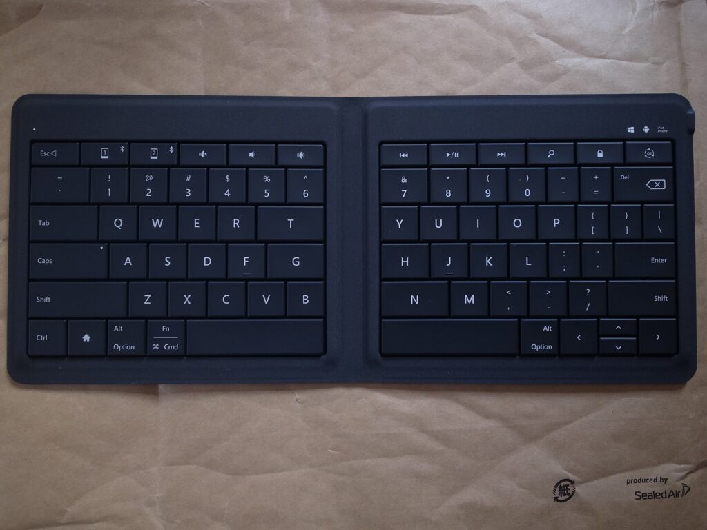 A folding Bluetooth keyboard opened flat, showing its two halves
