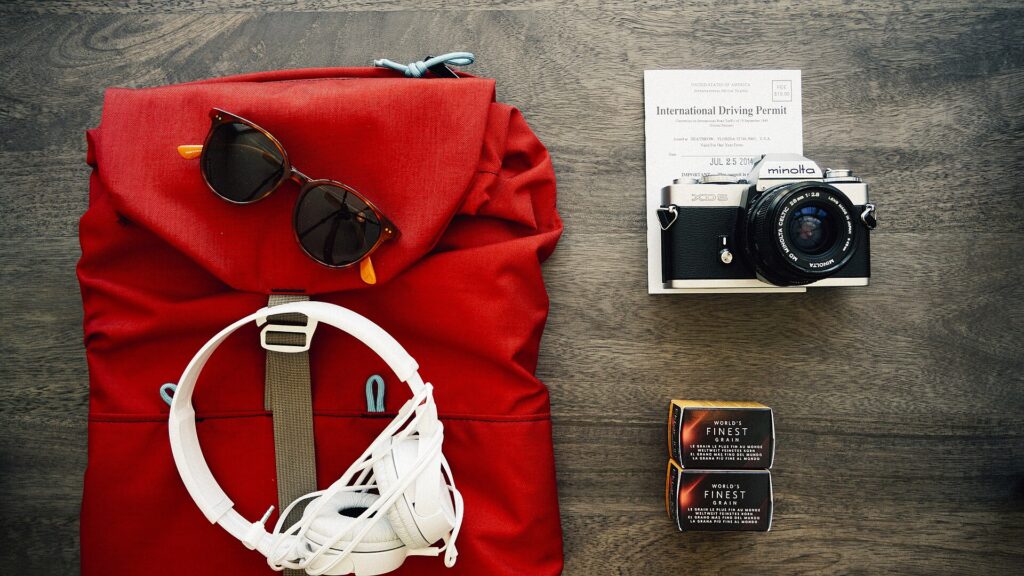 Clothes, shoes and travel items laid out next to a backpack ready for packing
