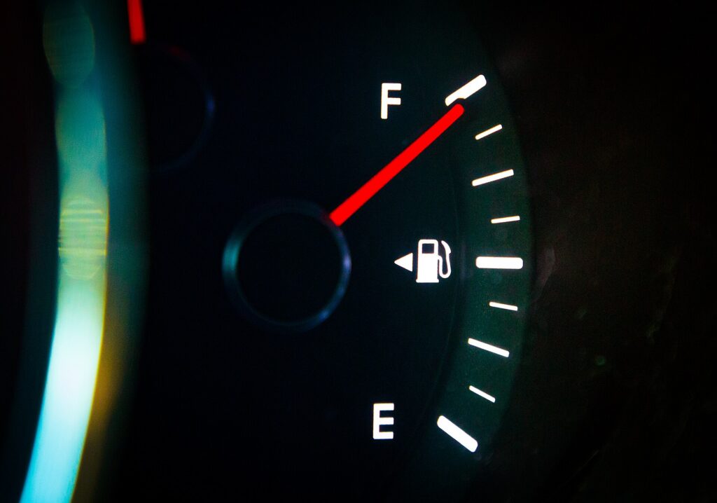 A car dashboard fuel gauge showing a full tank