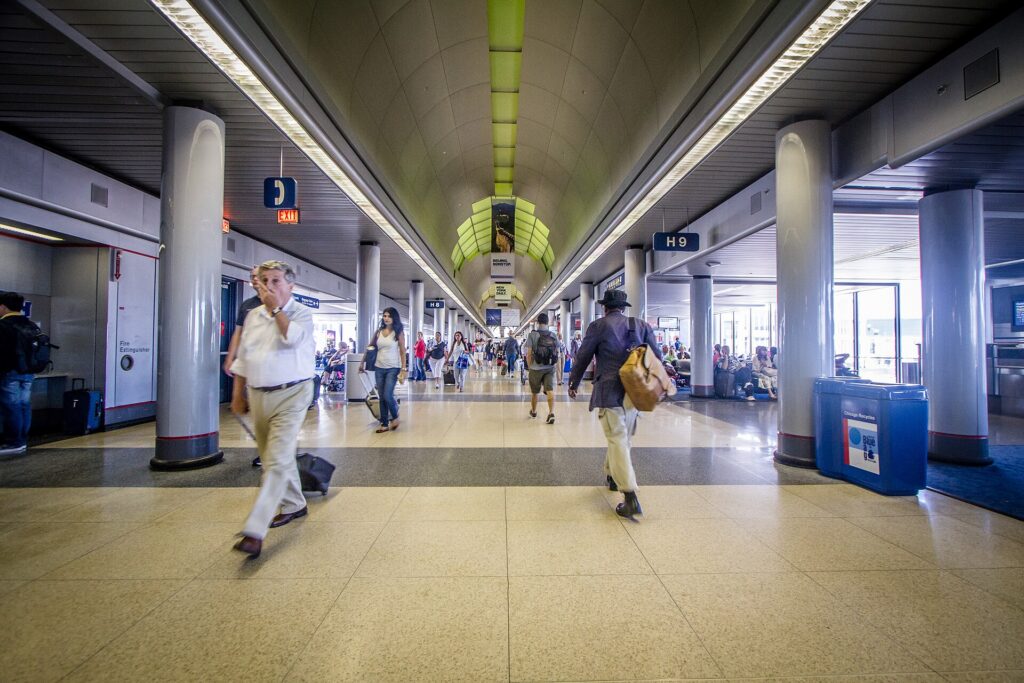 Travelers walking with bags along a long concourse at Chicago O'Hare International Airport