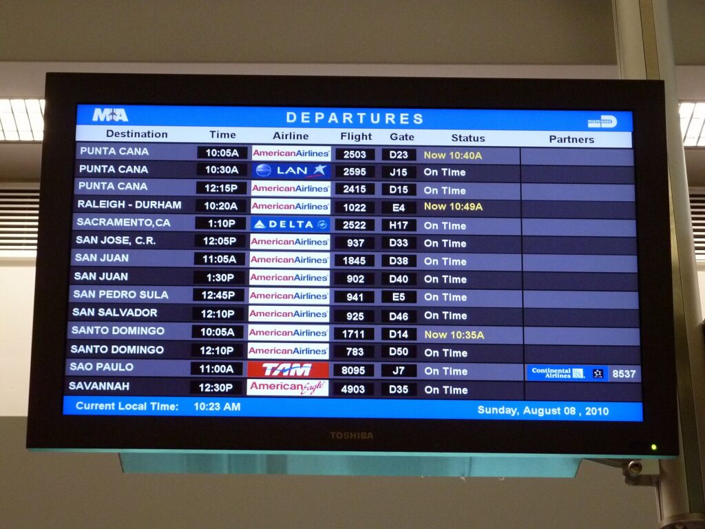A departures board listing flights at Miami International Airport