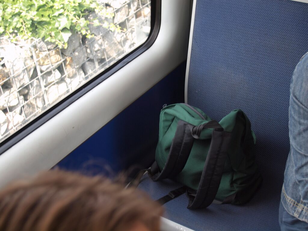 A backpack sitting on a seat on a metro train