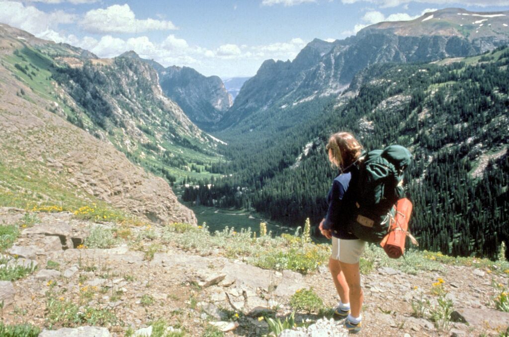 A backpacker carrying a large internal frame pack on a trail in Grand Teton National Park