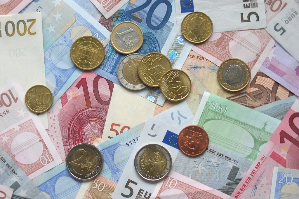 Euro banknotes and coins spread on a table