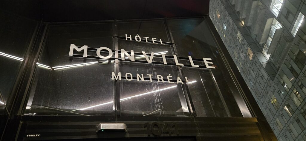 An illuminated hotel sign on a building facade in Montreal at night