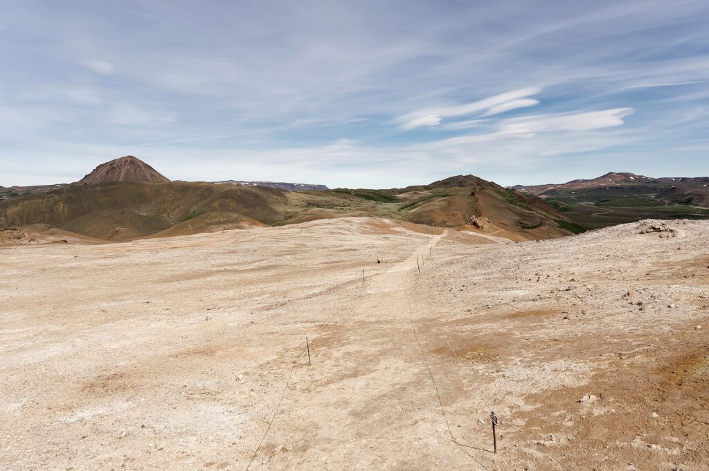 A marked hiking trail crossing a colorful volcanic mountainside