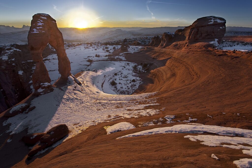 Delicate Arch in Arches National Park at sunset, with the La Sal Mountains behind