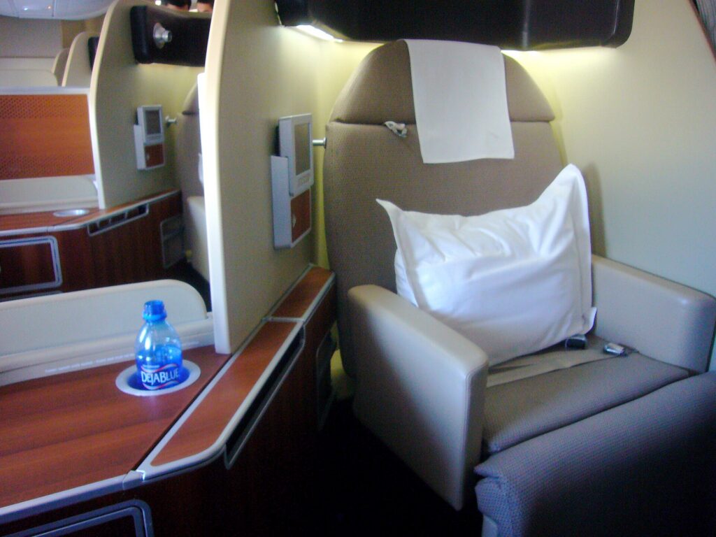 A private first class suite with a wide seat and screen on a long-haul aircraft