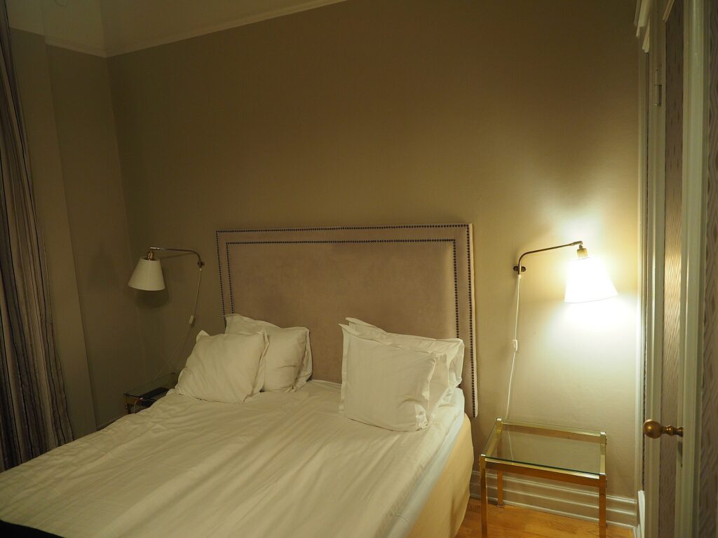 A double bed with bedside lamps in a hotel room
