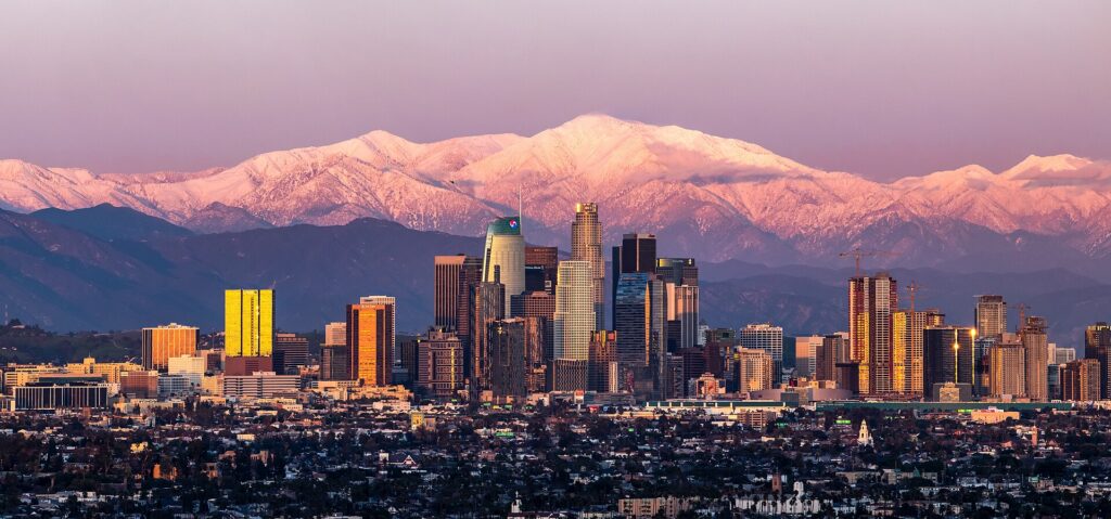 Downtown Los Angeles at sunset with snow-capped Mount Baldy behind