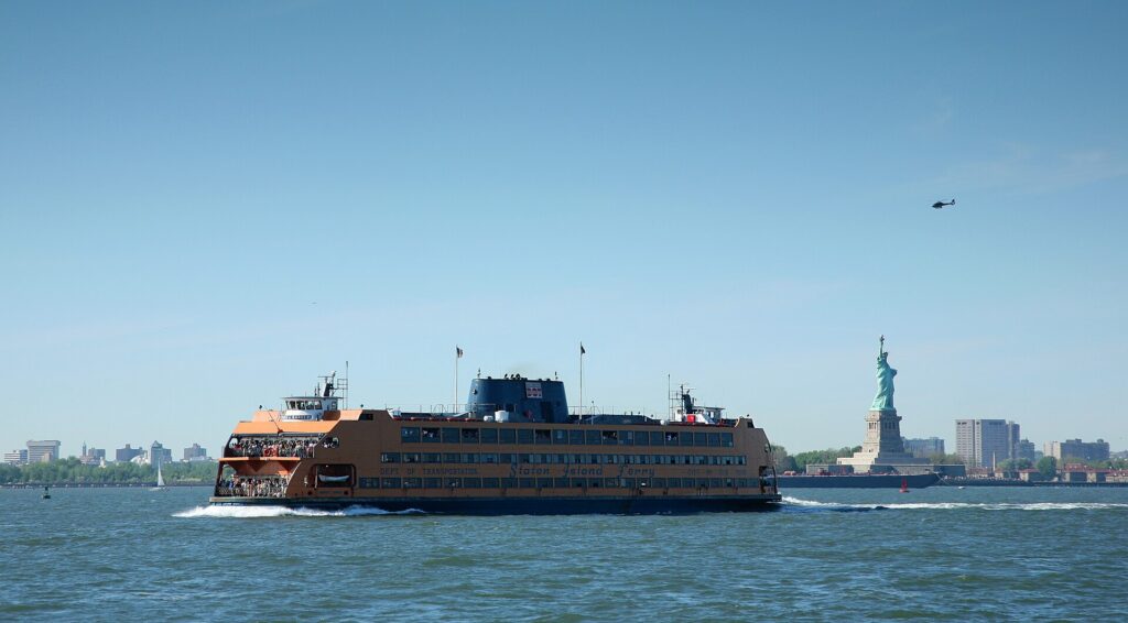 The Staten Island Ferry crossing the harbor with the Statue of Liberty behind